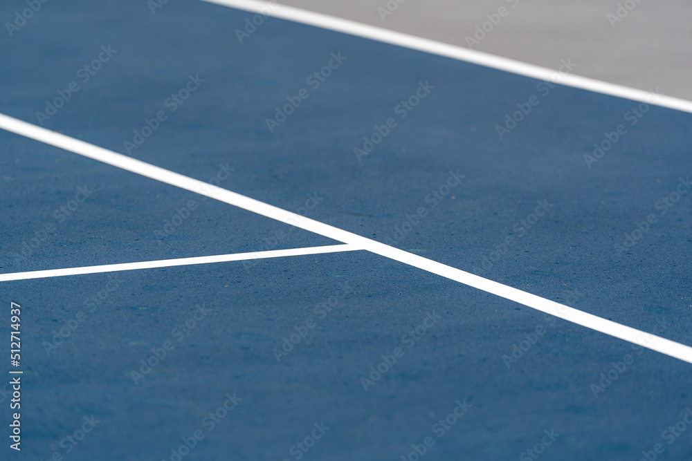 New blue tennis court with white lines and gray out of bounds	
