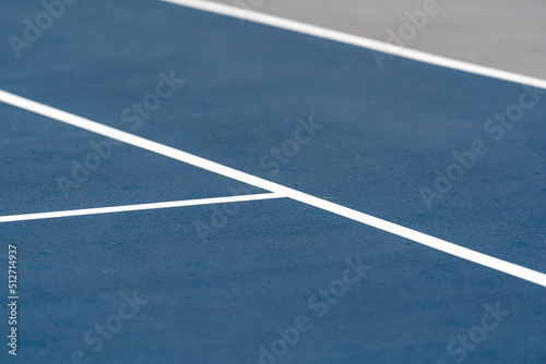 New blue tennis court with white lines and gray out of bounds 