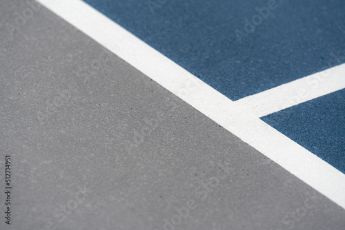 Blue tennis court with white lines and gray out of bounds  © Thomas