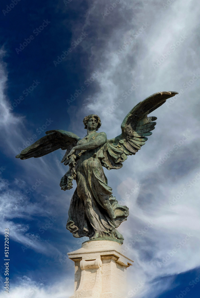 Fototapeta premium Rome, Italy - June 2000: Statue of an angel with outstretched wings against a blue sky background