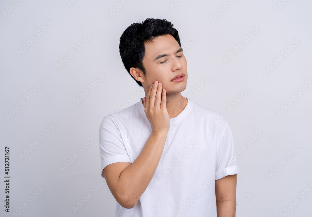 Handsome Asian man suffering from health problems and toothache on white. He touched his face with his hand. Handsome Asian man suffering from health problems and toothache on white. He touched his face with his hand.