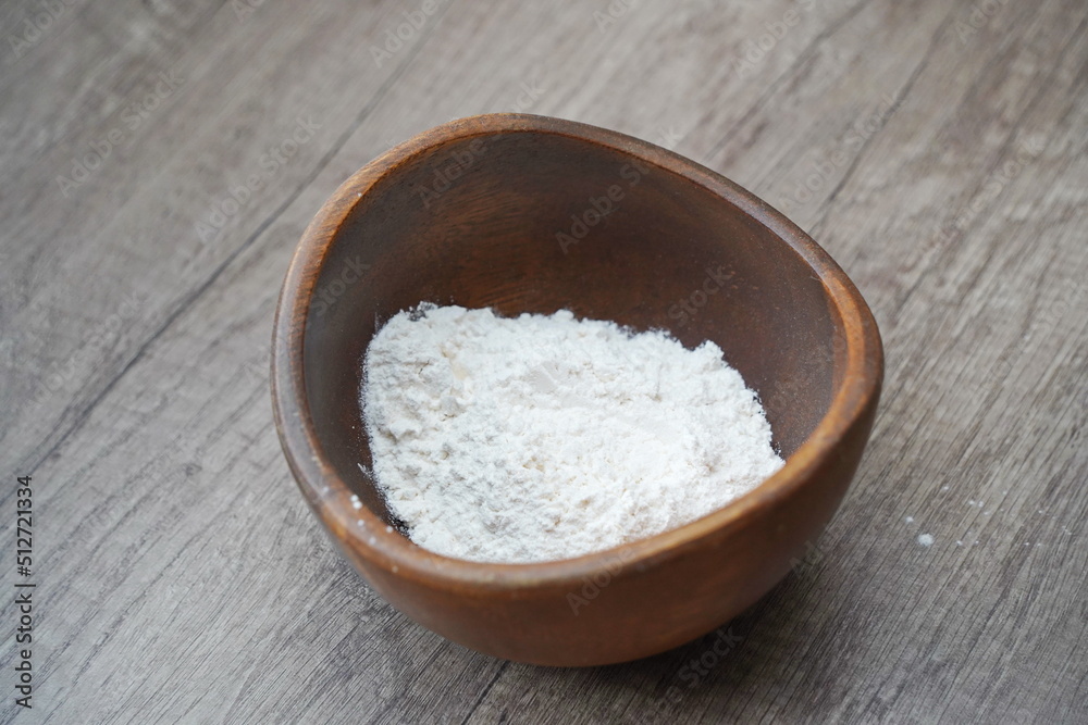 A handful of flour is in a plate on the table.