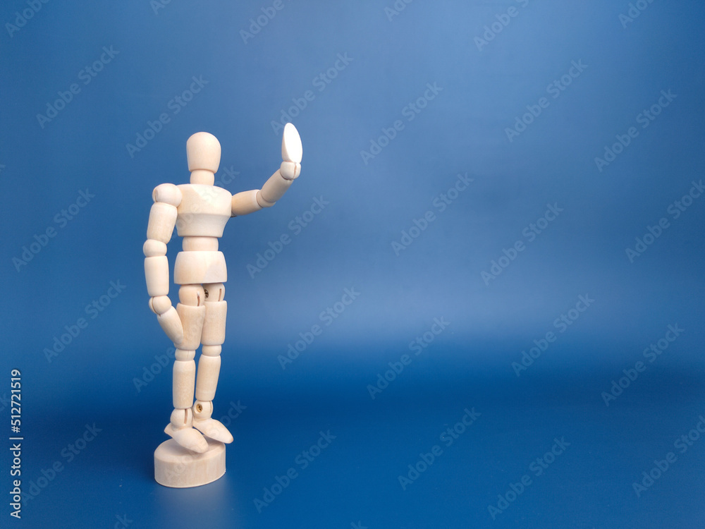 Wooden mannequin with action on a blue background with copy space. Wooden mannequin with action on a blue background with copy space.