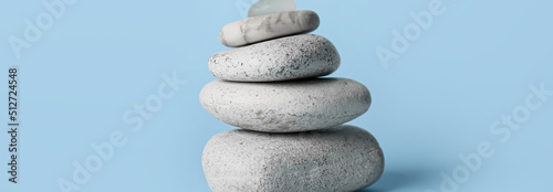 Stack of spa stones on light blue background. Zen concept