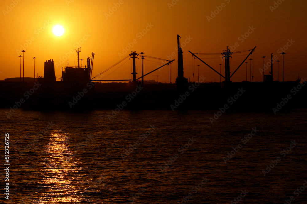 Beautiful sunset in the port of Dubai with silhouette of the ship.