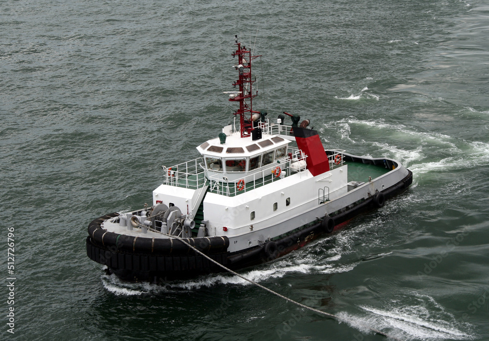 Powerful Port Tug assisting cargo ship in the port Powerful Port Tug assisting cargo ship in the port