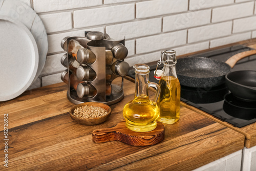 Bottles of sunflower oil with board on table near white brick wall