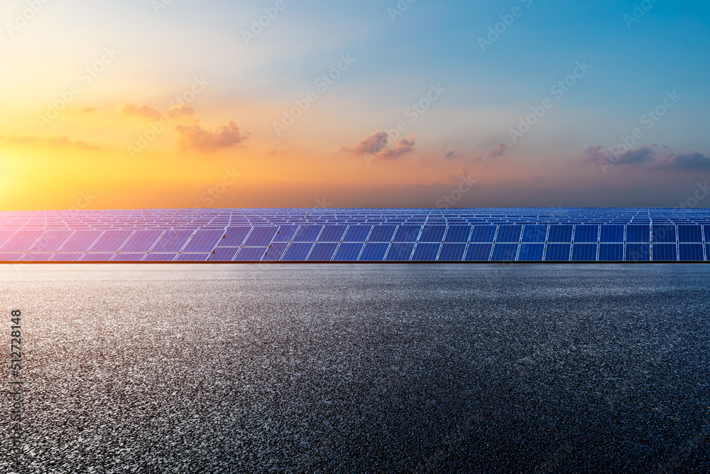 Empty asphalt road and solar power station at beautiful sunset. green energy concept.