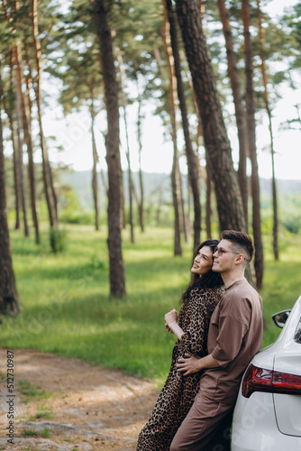Adorable young couple hugging near the car