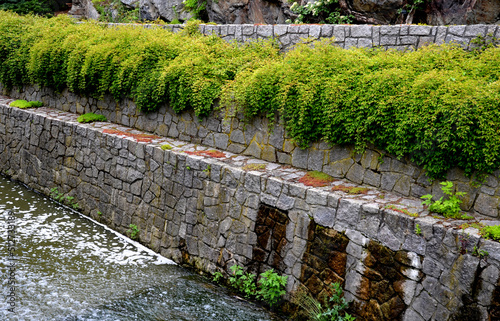 safety spillway of a lake dam  pond or other water area  reservoir. in case of clogging of the sluice  the water will drain out on the side through the stone wall and deceleration stones  sewerage