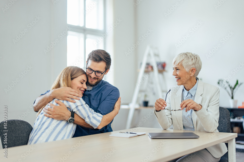 Couple in a hug, just finished meeting with an insurance agent. Couple in a hug, just finished meeting with an insurance agent.