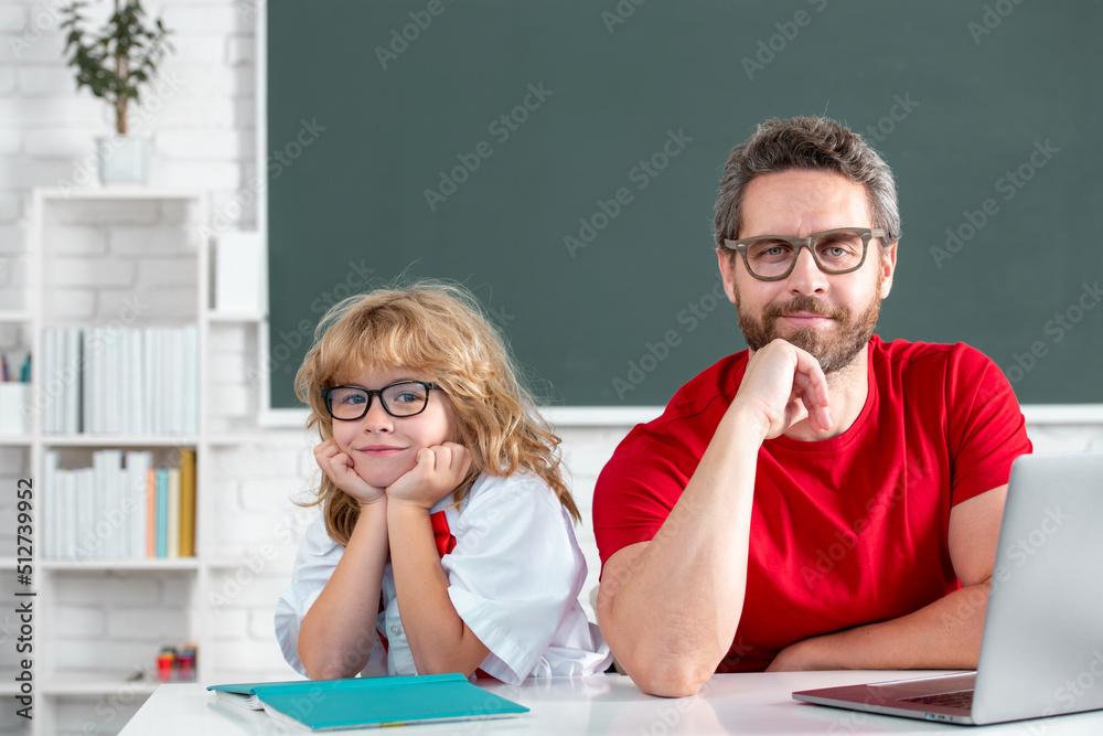 Education and learning concept. Pupil of primary elementary school has lesson. Kid boy with teacher learn english language or mathematics. Father and son doing homework at school. Education and learning concept. Pupil of primary elementary school has lesson. Kid boy with teacher learn english language or mathematics. Father and son doing homework at school.