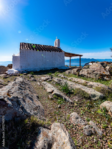 Saints Anargyroi chapel and lens leaks under the bright sunlight, Aegina island, Greece. photo