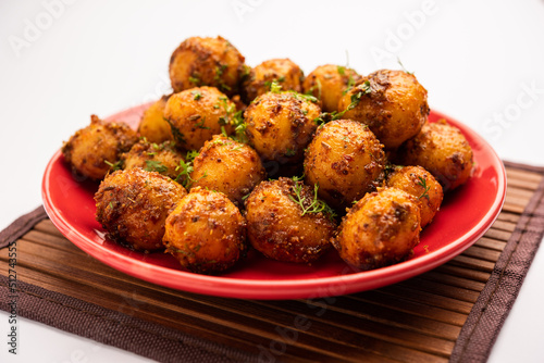Homemade Roasted Bombay potatoes. Pan fried little baby potatoes or aloo with jeera seeds and coriander in bowl © StockImageFactory
