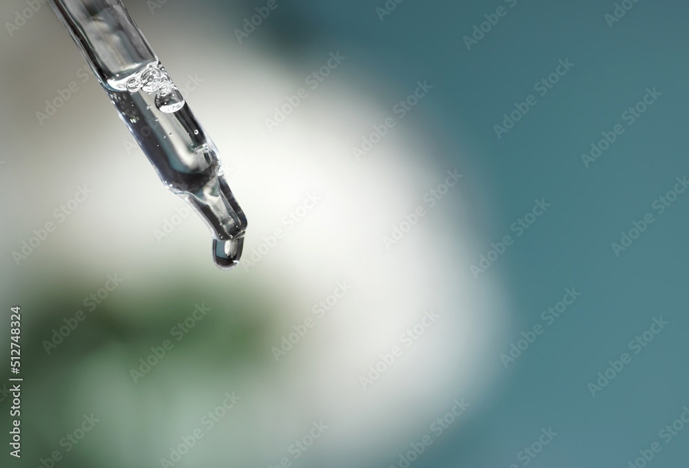 Pipette with transparent fluid hyaluronic acid or serum. Cosmetics, science and healthcare concept closeup. Dose of serum or retinol falls in a bottle. Front view. Beauty product presentation, macro