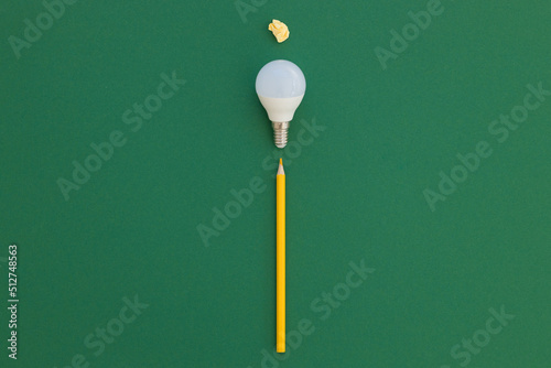 LED light bulb lies on a pastel green background. Energy saving concept. Minimalism, top view