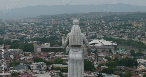 Arc aerial shot of the Kartlis Deda statue with Tbilisi cityscape in the back. photo