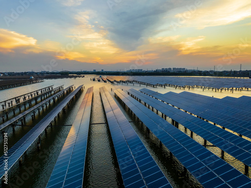 Aerial view of solar power station at beautiful sunset. solar photovoltaic power station on water. green energy concept.