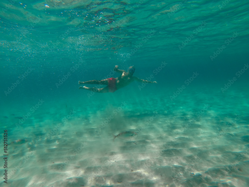 underwater man snorkeling in the sea withcrystal-clear waters concept of holiday relax summer beach diver in the sea	