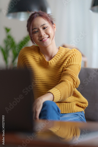 Portrait of happy asian beautiful girl making video calling with laptop and waving on phone screen at home. job interview remotely concept.