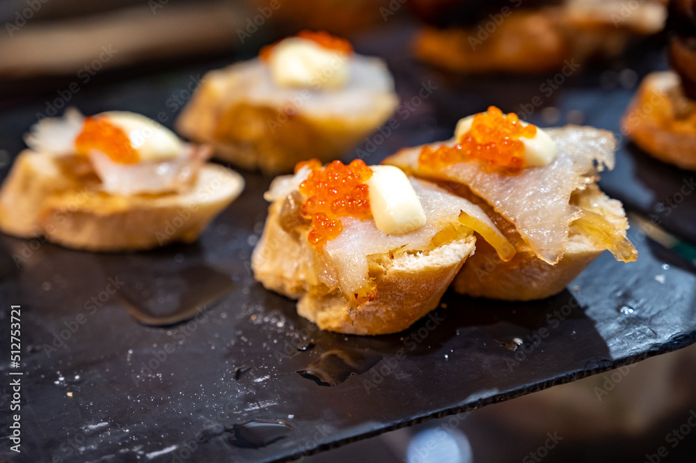 Typical snack of Basque Country and Navarre, pinchos or pinxtos served in bar, small slices of bread upon which ingredient or mixture of ingredients is placed, San Sebastian, Spain Typical snack of Basque Country and Navarre, pinchos or pinxtos served in bar, small slices of bread upon which ingredient or mixture of ingredients is placed, San Sebastian, Spain