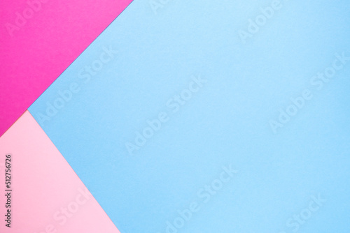 Light blue paper background with light pink and neon fuchsia color corner . Geometric figures, shapes, lines. Multicolor abstract flat lay composition. Copy space, top view.