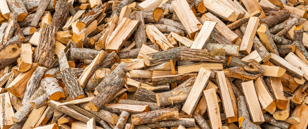 A pile of stacked firewood, prepared for heating the house. Firewood for ready heating in winter.Chopped firewood.environment background.Banner,advertisement. A pile of stacked firewood, prepared for heating the house. Firewood for ready heating in winter.Chopped firewood.environment background.Banner,advertisement.
