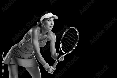 Female tennis player with racket ready to serve tennis ball, black and white portrait