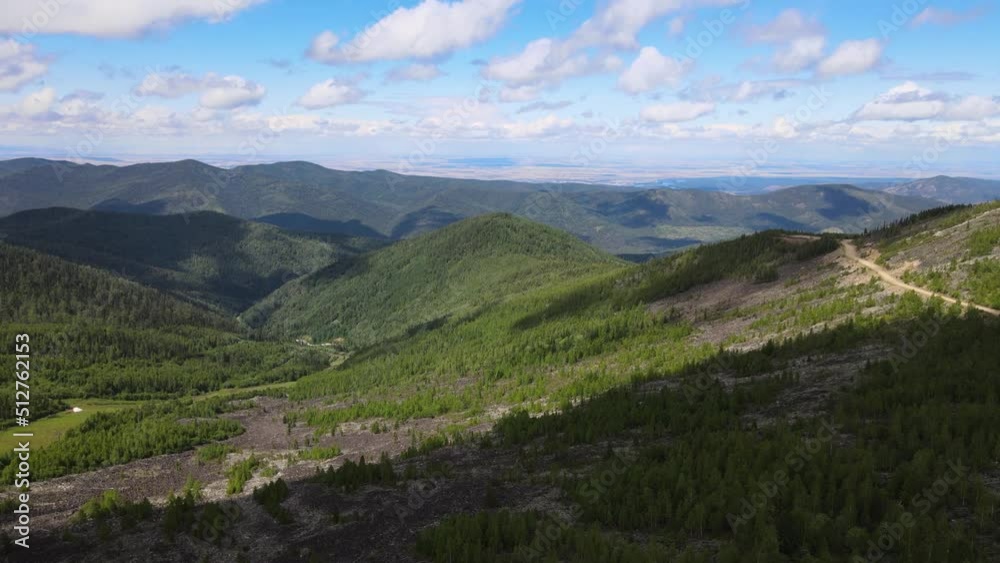 Drone flight over Sayan mountains with road and cloudy sky on a sunny day Drone flight over Sayan mountains with road and cloudy sky on a sunny day