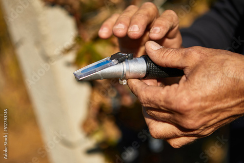Refractometer in the hands of a man on a vineyard