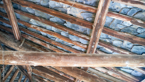 Vigas de madera y placas de pizarra en tejado rústico de casa rural
