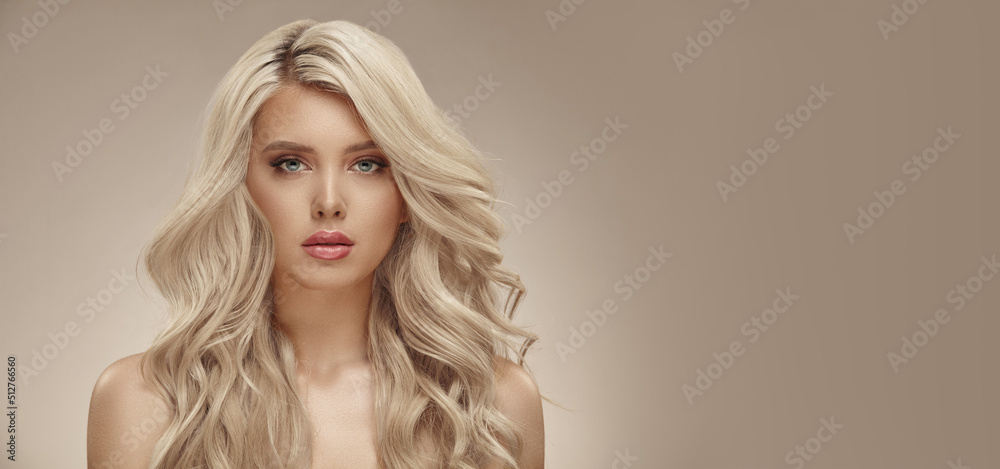 Much attractive blonde woman with long healthy curly hair on beige isolated with free copy space - obrazy, fototapety, plakaty 