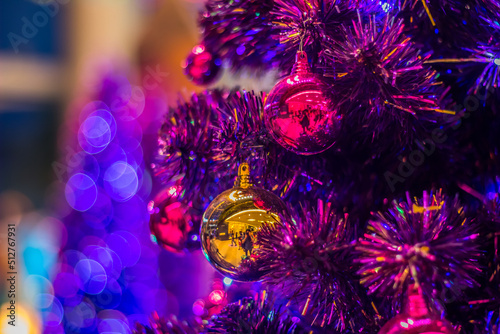 Christmas balls on colorful Christmas tree with blurred background.