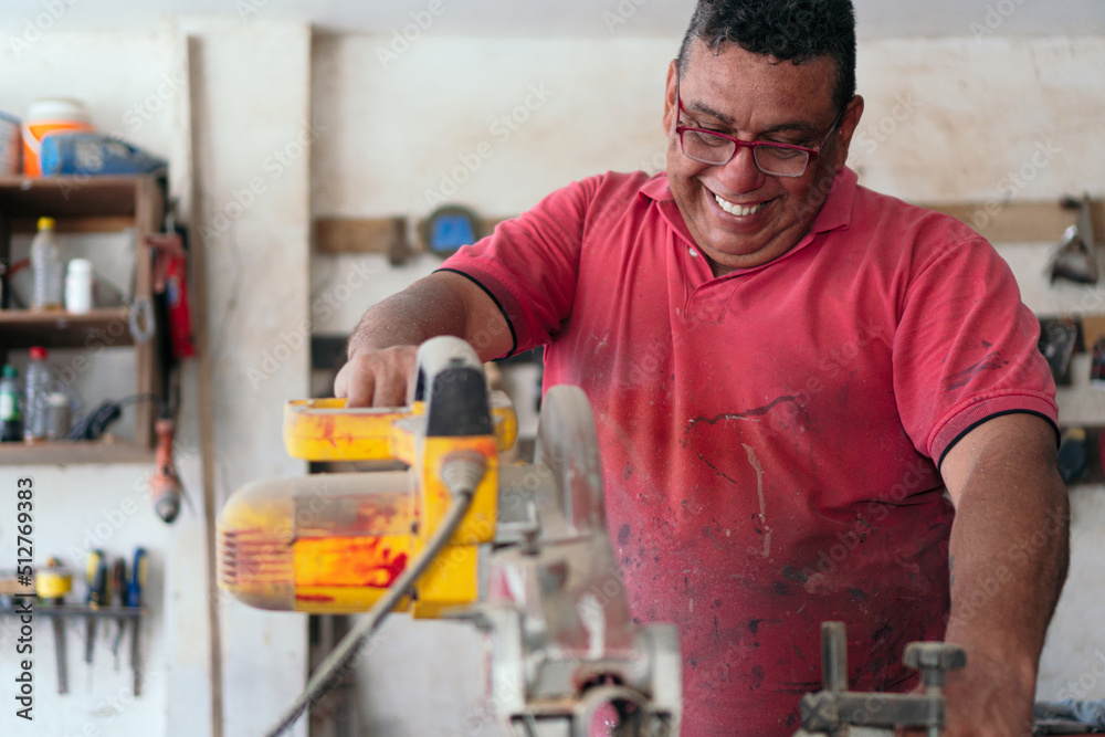 Latin Carpenter using a circular saw in the workshop Latin Carpenter using a circular saw in the workshop