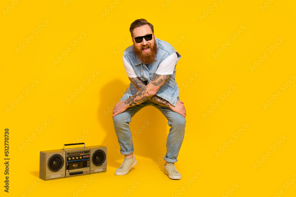 Naklejka premium Photo of pretty funny guy dressed denim vest rising dark glasses enjoying songs boombox dancing isolated yellow color background