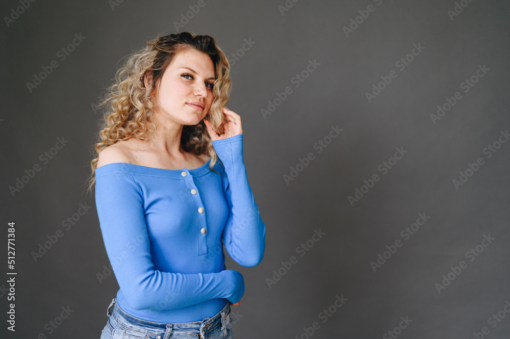 Young Woman in Blue Jacket is holding lock of hair. Free space for advertising. Girl chooses Goods Young Woman in Blue Jacket is holding lock of hair. Free space for advertising. Girl chooses Goods