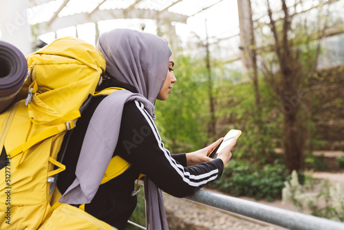Photo muslim woman looking at her mobile - concept, backpacking, traveling in nature -