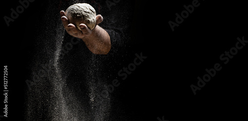 White flour flying into air as pastry chef in white suit slams ball dough on white powder covered table. concept of nature, Italy, food, diet and bio