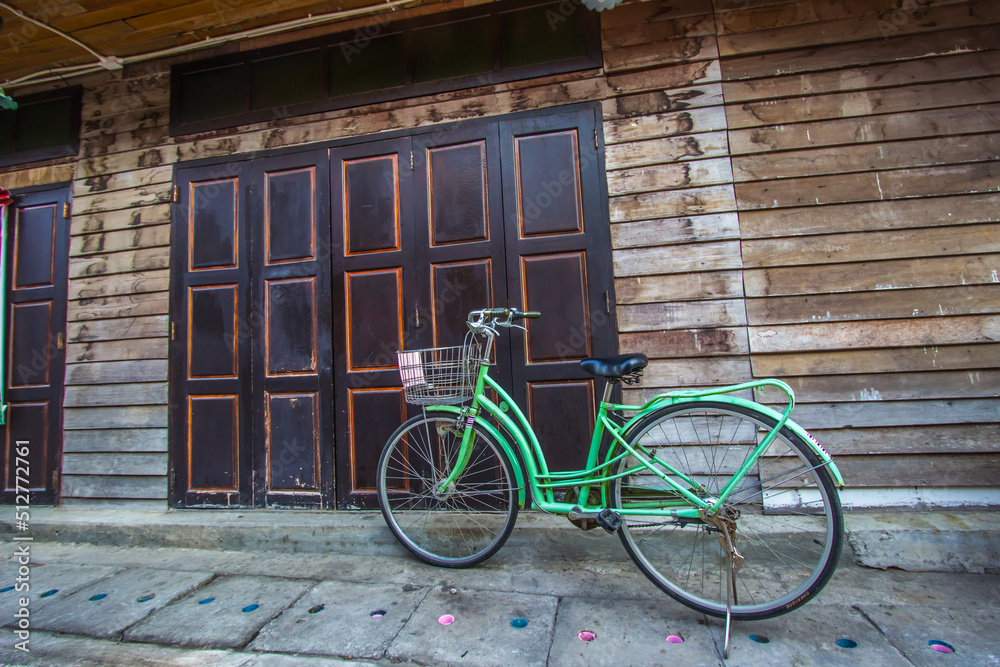 Chiang Khan,Loei,Thailand on DEC23,2018:A bicycle and old wooden house at Chiang Khan’s walking street. Chiang Khan,Loei,Thailand on DEC23,2018:A bicycle and old wooden house at Chiang Khan’s walking street.