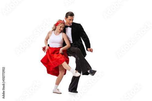 Excited young couple of dancers in vintage retro style outfits dancing social dance isolated on white background. Art, music, fashion, style concept