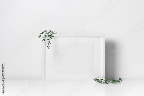 Blank landscape frame mockup in white minimalistic interior with botanical decorations