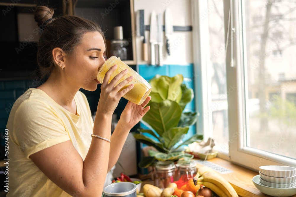 Young woman making a healthy smoothie for breakfast Young woman making a healthy smoothie for breakfast