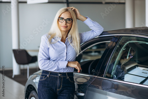Buisness woman choosing a car in a car showroom © Petro