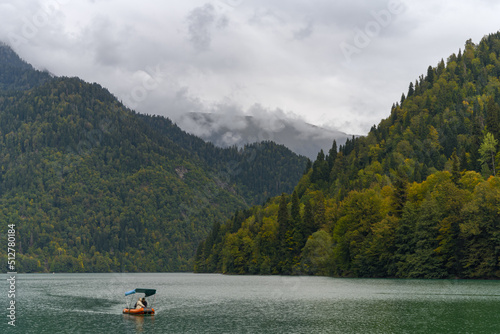 Lake Ritsa in Abkhazia with clear turquoise water surrounded by picturesque mountains with lush vegetation.