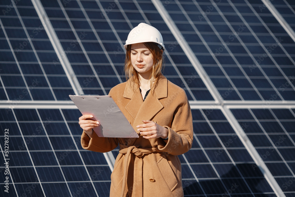 Young woman with checklist standing at solar plant Young woman with checklist standing at solar plant