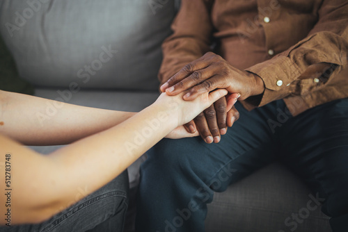 Female healthcare worker holding hands of senior man at care home, focus on hands. Doctor helping old patient with Alzheimer's disease. Female carer holding hands of senior man
