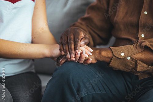 Closeup shot of a young woman holding a senior man's hands in comfort. Cropped shot of a senior man and a nurse holding hands. Not just a caregiver but a confidant photo