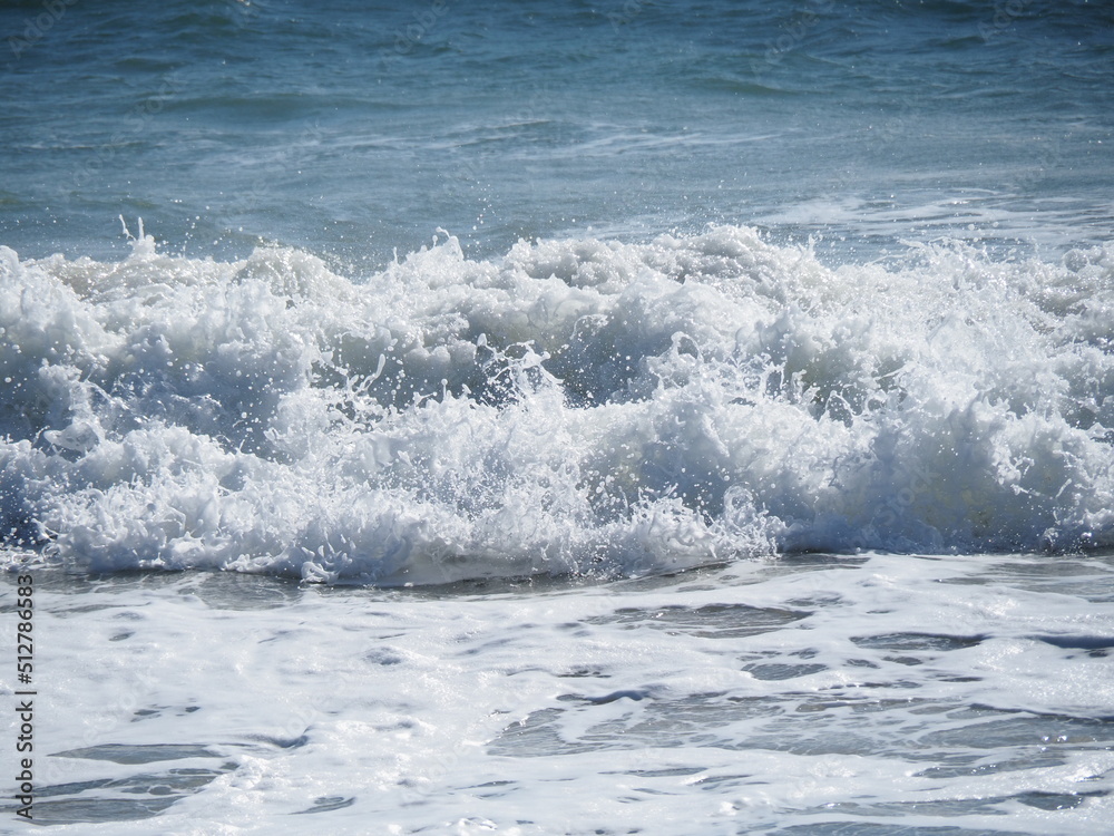 White bubbling water as waves are crushing on blue ocean. White bubbling water as waves are crushing on blue ocean.
