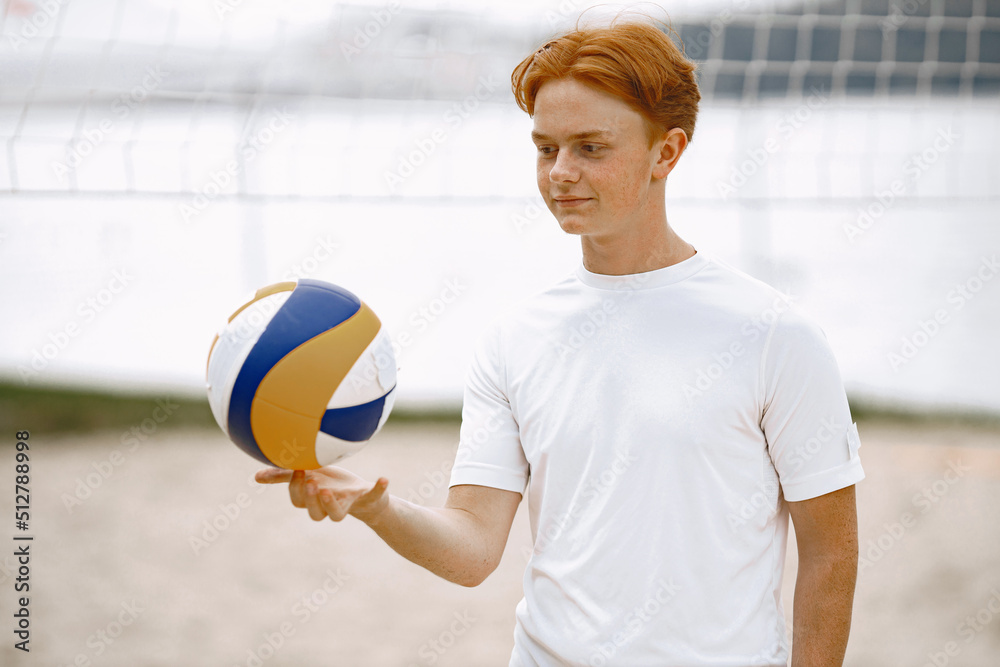 Ginger hair boy play with volleyball ball