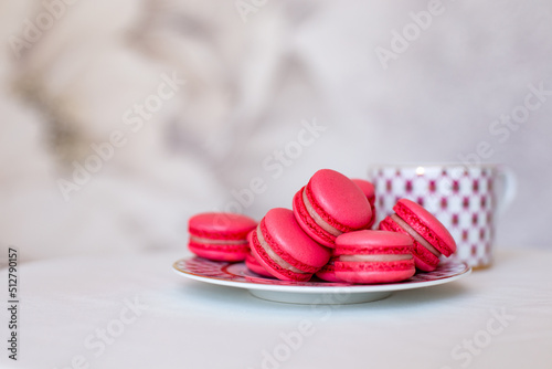 Sweet pink macaroons on the table next to a classic cup of tea. Vintage tea party. 5 o'clock. Sweets and pastries, desserts with their own hands. Handmade